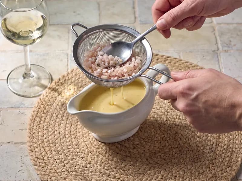 Beurre blanc filtrato al colino fine in una salsiera calda, setoso e chiaro