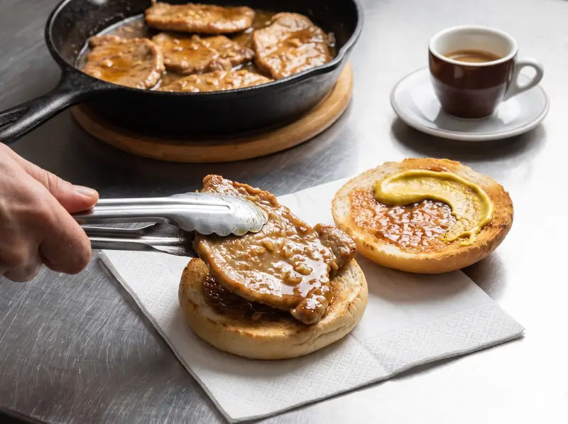 Bifana rolls filled with pork cutlets, sauce and a smear of mustard