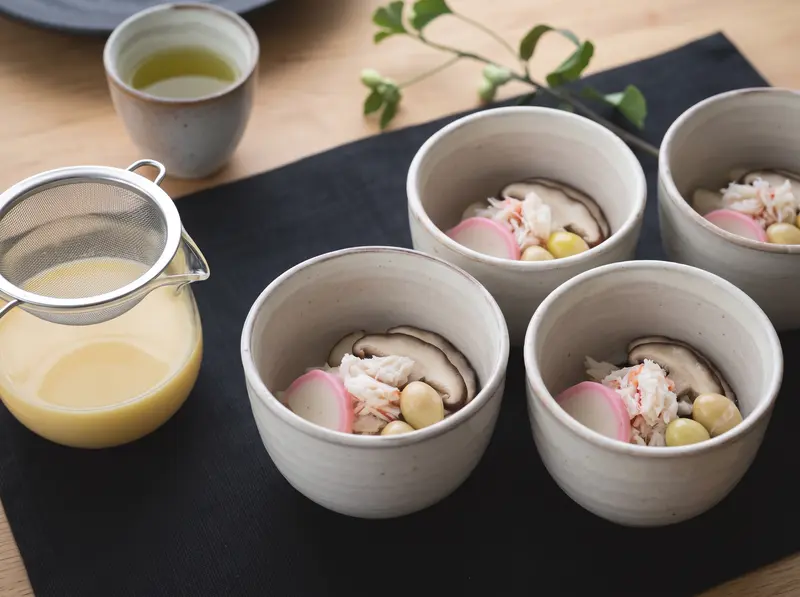 Chawanmushi cups filled with shiitake, crab meat, pink kamaboko and a ginkgo nut before the custard is poured