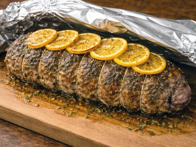 Roast leg of lamb resting loosely under foil before carving
