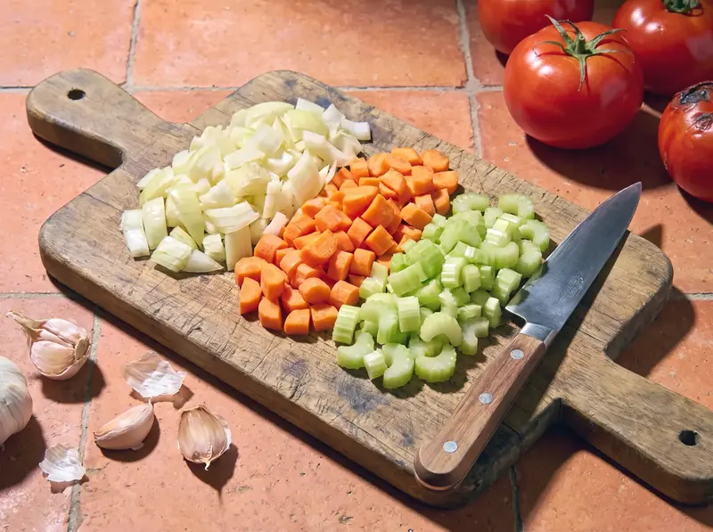 Cipolla, carota e sedano tritati in tre mucchietti per il soffritto