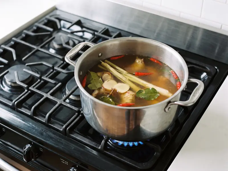 Tom Yum: Zitronengras, Galgant, Makrut-Limettenblätter und Chilis ziehen in klarer Garnelenbrühe