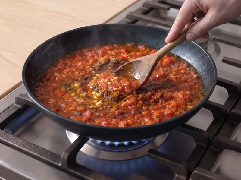 Tomatoes cooking down with garlic, cumin and paprika into the zaalouk base